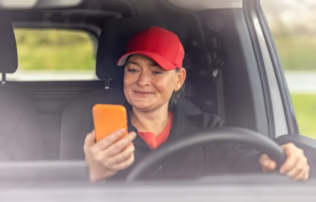 Woman looking at her phone while stationary in her car